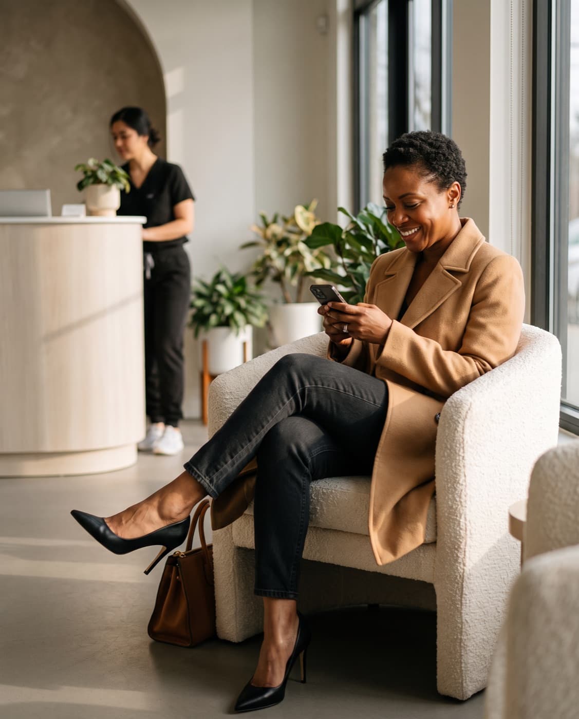 A patient in the clinic lounge checking her treatment plan on her phone